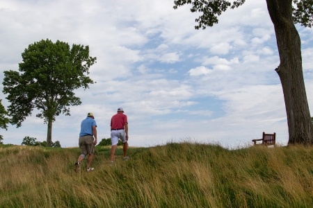 Two men walking through fescue up a hill