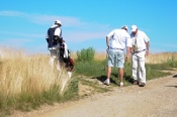 Golfers and caddie near fescue.